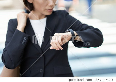 A businesswoman who seems to be concerned about time A businesswoman who seems to be concerned about time 137246083