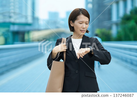 A businesswoman who seems to be concerned about time A businesswoman who seems to be concerned about time 137246087