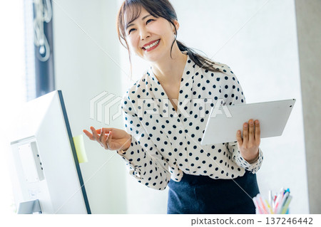 一位在辦公室工作的年輕女性 137246442