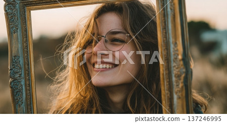 Young woman smiling through an antique picture frame 137246995