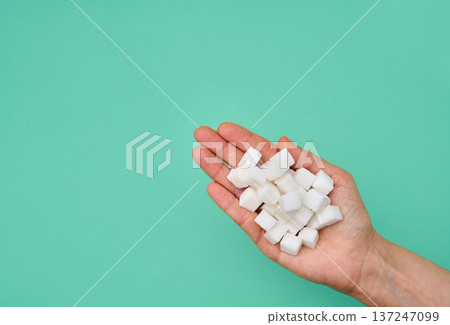 Hand holding sugar cubes closeup 137247099