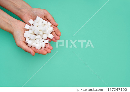Hands holding pile of sugar cubes 137247100