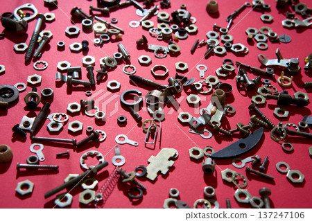 Metal nuts and bolts on red background 137247106