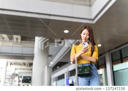 一名女子在機場使用智慧型手機。照片由關西國際機場(KIX)提供。 一名女子在機場使用智慧型手機。照片由關西國際機場(KIX)提供。 137247138