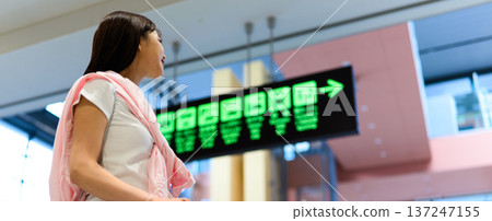 A woman checks the information display. Photo courtesy of Kansai International Airport (KIX) 137247155