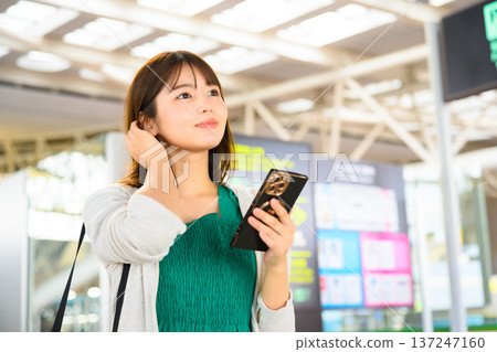 A woman checking her smartphone at the airport. Photo courtesy of Kansai International Airport (KIX) A woman checking her smartphone at the airport. Photo courtesy of Kansai International Airport (KIX) 137247160
