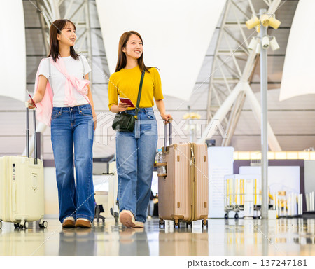 Two people pulling travel bags at the airport ■Photography cooperation: Kansai International Airport (KIX) 137247181