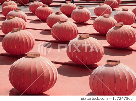 Numerous round, red Chinese lanterns sit in tidy rows atop a matching crimson floor. These lanterns, which are iconic symbols of the Spring Festival (Chinese New Year). Numerous round, red Chinese lanterns sit in tidy rows atop a matching crimson floor. These lanterns, which are iconic symbols of the Spring Festival (Chinese New Year). 137247863