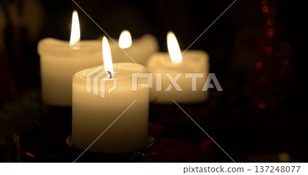Warm candles glow in dark room creating soft light during evening gathering Warm candles glow in dark room creating soft light during evening gathering 137248077