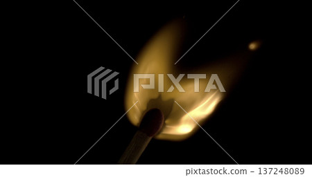 Flame from a lit match in darkness with smoke curling above and bright light shining below Flame from a lit match in darkness with smoke curling above and bright light shining below 137248089