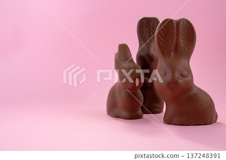 Chocolate Easter eggs and colorful sweets on a pink background. Chocolate Easter eggs and colorful sweets on a pink background. 137248391
