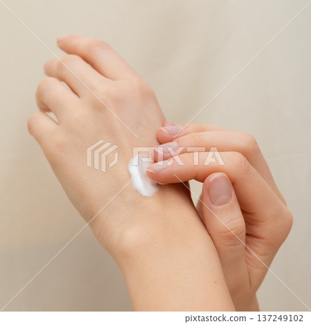 Close up hands of woman gently massaging hydrating cream onto her hands, emphasizing daily skin care, beauty treatment, and a healthy skin routine for smoothness and moisture Close up hands of woman gently massaging hydrating cream onto her hands, emphasizing daily skin care, beauty treatment, and a healthy skin routine for smoothness and moisture 137249102