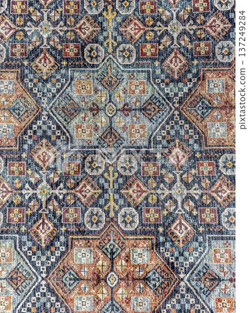 Vintage-style rug with a colorful, intricate Persian or Turkish ornamental pattern. Abstract background texture. 137249284