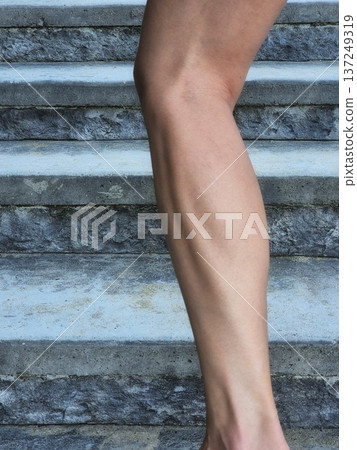 female athlete's powerful calf muscle, highlighting the definition and strength on the leg. female athlete's powerful calf muscle, highlighting the definition and strength on the leg. 137249319