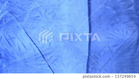 Ice surface shows detailed lines and patterns that reflect light in a blue hue during a cold winter day 137249654