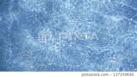 Clear water reflects sunlight in a swimming pool during midday, creating patterns on the surface Clear water reflects sunlight in a swimming pool during midday, creating patterns on the surface 137249680