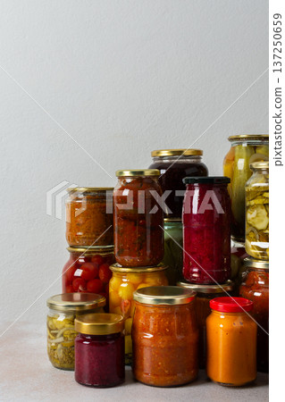 Canning is a common activity in the kitchen as jars filled with vegetables and fruits line the counter. This practice helps in preserving food for winter use and has a long tradition 137250659