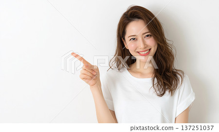 一位二十多歲的日本女性的肖像,她指著某個方向微笑,背景是白色。 一位二十多歲的日本女性的肖像,她指著某個方向微笑,背景是白色。 137251037