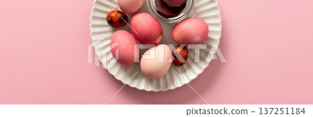 A variety of dyed Easter eggs in soft pink and vibrant shades rest on a decorative plate, a small bowl of beets, a way to dye eggs pink, ready for an Easter celebration filled with joy, banner A variety of dyed Easter eggs in soft pink and vibrant shades rest on a decorative plate, a small bowl of beets, a way to dye eggs pink, ready for an Easter celebration filled with joy, banner 137251184