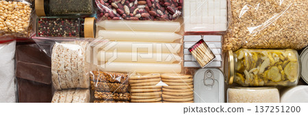 Home food supplies for quarantine and isolation, including canned food, cereals, pasta, and essential staples for survival, survival during military operations, the concept of stay at home, banner Home food supplies for quarantine and isolation, including canned food, cereals, pasta, and essential staples for survival, survival during military operations, the concept of stay at home, banner 137251200