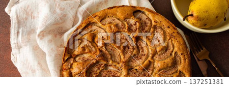 A fresh pear pie is placed on a cloth on a table. Nearby, a bowl holds ripe pears and a small vase has flowers. The setting looks warm and inviting for sharing a treat, banner A fresh pear pie is placed on a cloth on a table. Nearby, a bowl holds ripe pears and a small vase has flowers. The setting looks warm and inviting for sharing a treat, banner 137251381