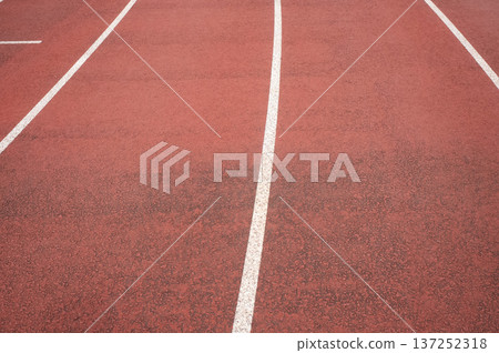 Empty running track with white lane lines perspective 137252318