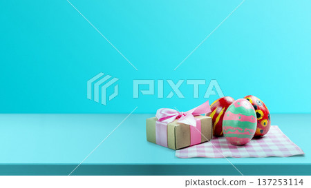 Three hand-painted Easter eggs and a small gift box with a pink ribbon sit on a checkered napkin against vibrant blue background. This festive composition offers ample copy space for holiday messages Three hand-painted Easter eggs and a small gift box with a pink ribbon sit on a checkered napkin against vibrant blue background. This festive composition offers ample copy space for holiday messages 137253114