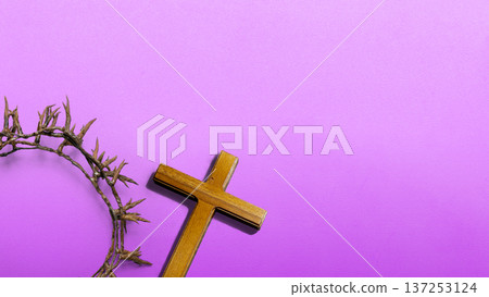 Religious Christian symbols of a wooden cross and crown of thorns on a textured purple background. Concept for Lent, Holy Week, Good Friday, and Easter themes with copy space for text Religious Christian symbols of a wooden cross and crown of thorns on a textured purple background. Concept for Lent, Holy Week, Good Friday, and Easter themes with copy space for text 137253124