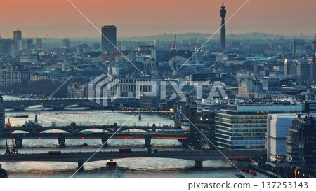 England, London: Aerial view urban city landscape with the BT Tower, River Thames, buildings and bridges during vibrant sunset. Drone panorama. Blue evening color toning. Drone flight 137253143