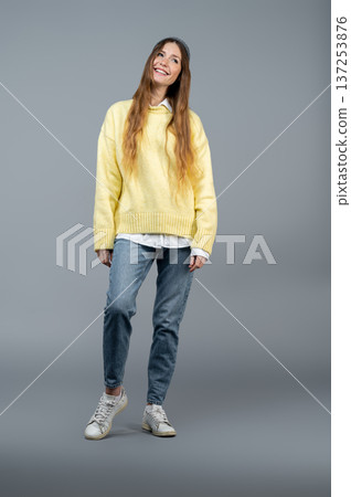 Slim tall young woman on a grey background looking confident Slim tall young woman on a grey background looking confident 137253876