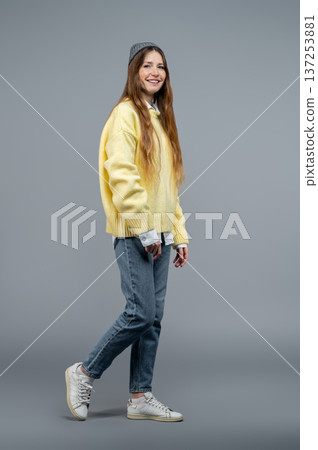Slim tall young woman on a grey background looking confident Slim tall young woman on a grey background looking confident 137253881