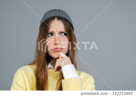 Pretty young woman in grey hat feeling unpleased 137253985
