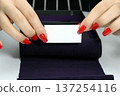 business card in women's hands with a manicure. business card 137254116