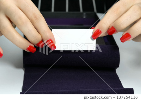 business card in women's hands with a manicure. business card business card in women's hands with a manicure. business card 137254116
