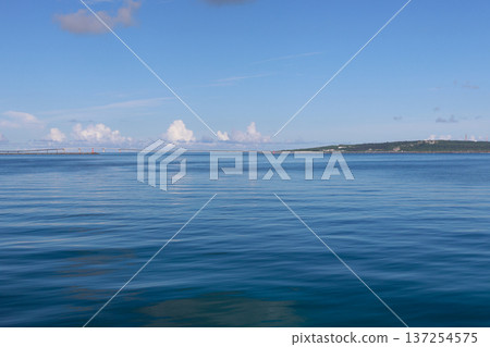 Calm blue sea and the silhouette of a distant island on the horizon Calm blue sea and the silhouette of a distant island on the horizon 137254575