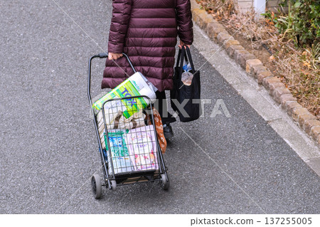 日本橫濱的城市景觀。可重複使用的購物袋(環保袋)和購物車。老化社會。戴著口罩的老婦人購物回來。 日本橫濱的城市景觀。可重複使用的購物袋(環保袋)和購物車。老化社會。戴著口罩的老婦人購物回來。 137255005