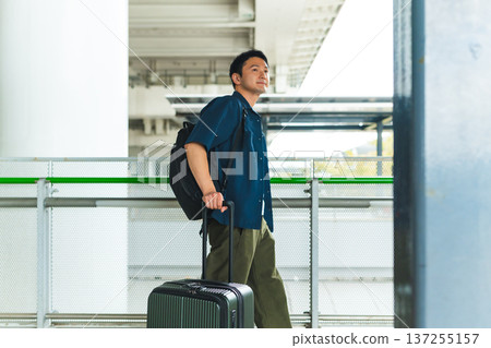 一名男子在車站攜帶行李。照片由關西國際機場（KIX）提供。 137255157