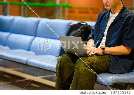一名男子在機場使用電腦。照片由關西國際機場(KIX)提供。 一名男子在機場使用電腦。照片由關西國際機場(KIX)提供。 137255172