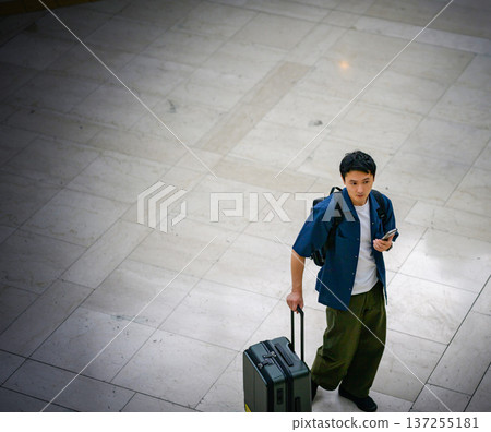 一名男子在機場使用手機。照片由關西國際機場（KIX）提供。 137255181