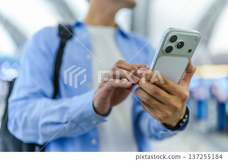 A man using a smartphone at the airport. Photo courtesy of Kansai International Airport (KIX) 137255184