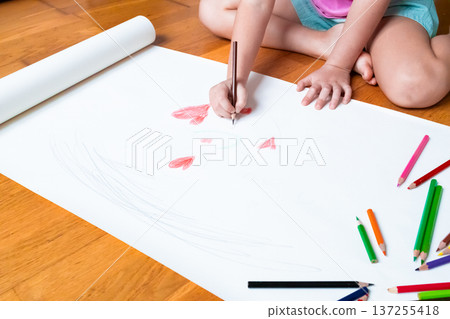 Young caucasian female child drawing with colored pencils on large white paper Young caucasian female child drawing with colored pencils on large white paper 137255418