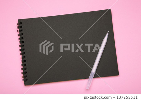 Black notebook with black pen on pink background. Mockup Black notebook with black pen on pink background. Mockup 137255511