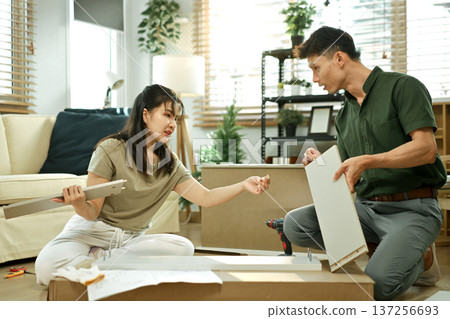 Photo series of young asian couple assembly a new furniture at home Photo series of young asian couple assembly a new furniture at home 137256693