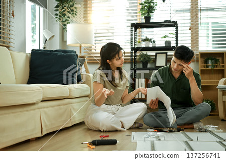 Frustrated asian couple having problems while assembling furniture Frustrated asian couple having problems while assembling furniture 137256741