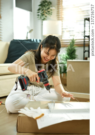 Woman is engaged in assembling the cabinet Woman is engaged in assembling the cabinet 137256757