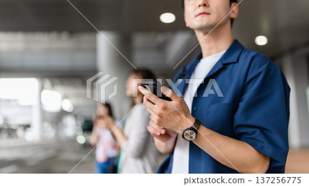 A man operates a smartphone. Photo courtesy of Kansai International Airport (KIX) 137256775