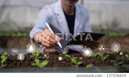 Agricultural scientist monitoring seedling growth with tablet and digital soil data for precision farming and pH control Agricultural scientist monitoring seedling growth with tablet and digital soil data for precision farming and pH control 137256834