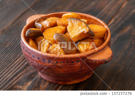 Sauteed baby Eryngii mushrooms caramelized to golden perfection served in rustic clay pot elegantly Sauteed baby Eryngii mushrooms caramelized to golden perfection served in rustic clay pot elegantly 137257276