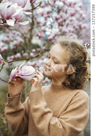 Girl Appreciating Blossoming Magnolia in Springtime 137257399