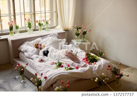 Peaceful floral scene, Serene woman among blooming tulips, Calm setting with flowers and gentle sunlight Peaceful floral scene, Serene woman among blooming tulips, Calm setting with flowers and gentle sunlight 137257737